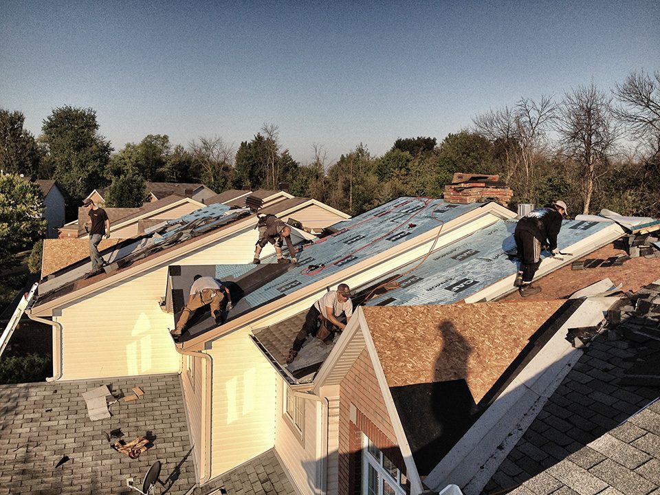 A group of men working on the roof of a building.