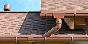 A brown roof with gutter and gutter guards.